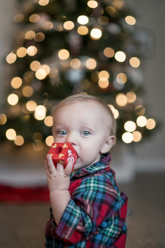 Baby sucking on something with xmas tree stock Baby sucking on something with xmas tree stock