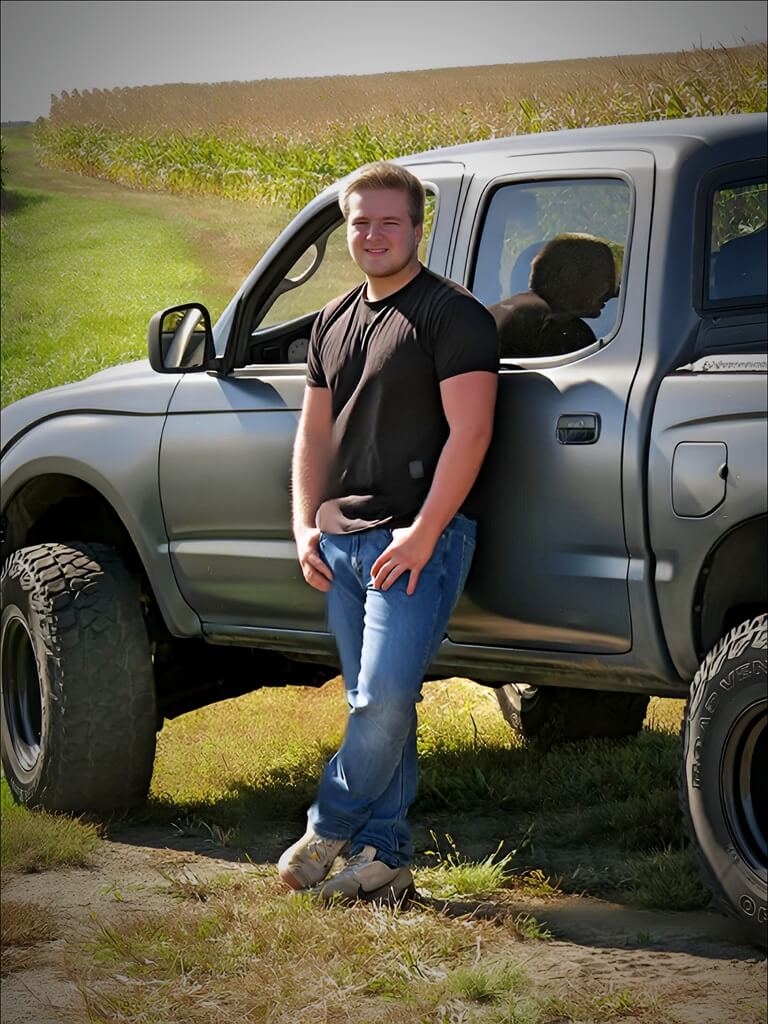 Senior pic black shirt boy in front of truck Senior photo of boy in black shirt leaning against his truck, hands in his pocket