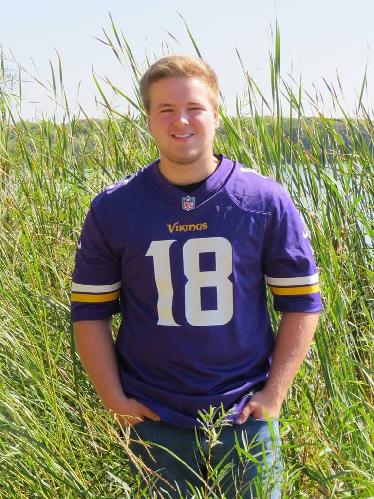 Senior Portrait with Vikings Jersey in field Senior Photo with Vikings Jersey standing in field