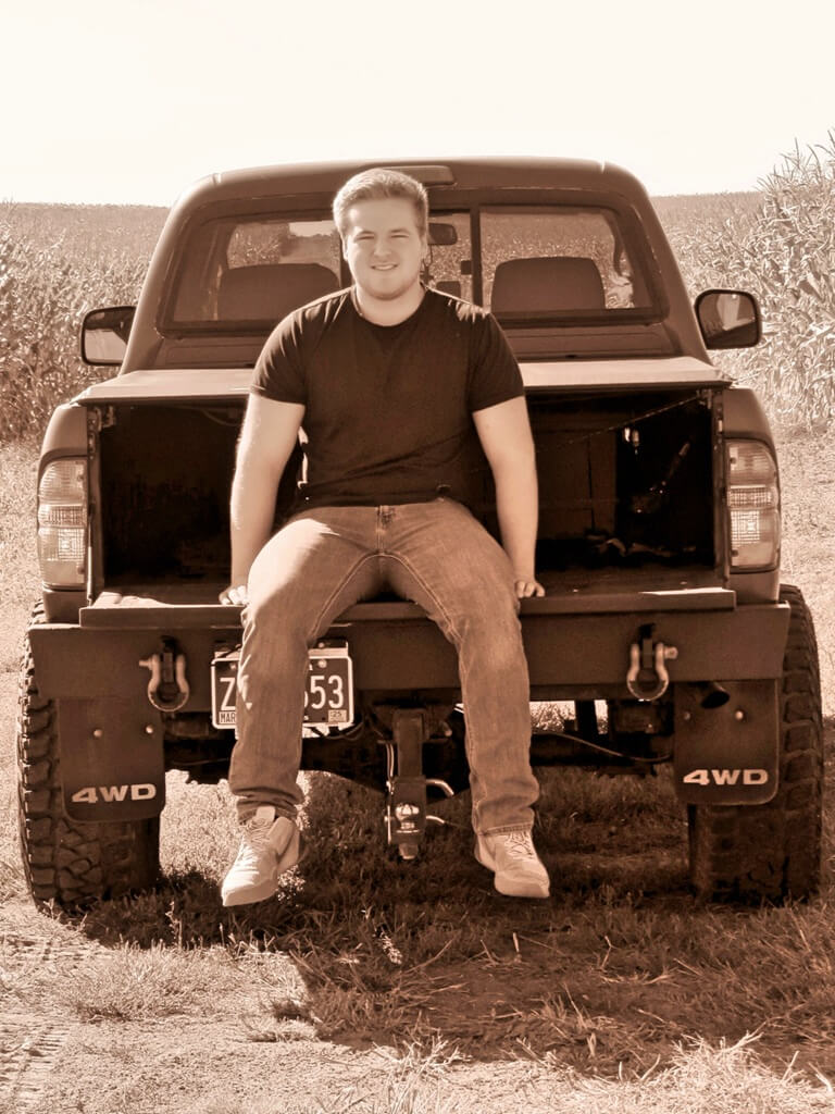 Senior Photo of boy sitting in his truck bed Senior Photo of boy sitting in the bed of his truck, black and white