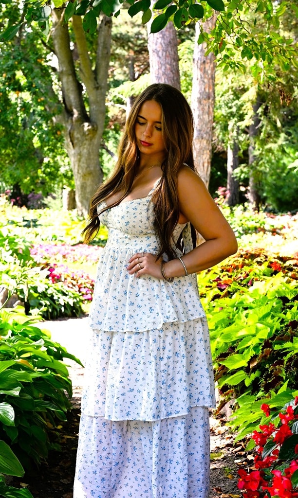 Senior photo of girl on a path at the flower park, looking down in white dress Senior Photo of girl at the flower park looking down at the ground