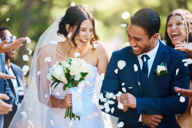 Wedding picture walking down the isle after getting married and guests are throwing confetti